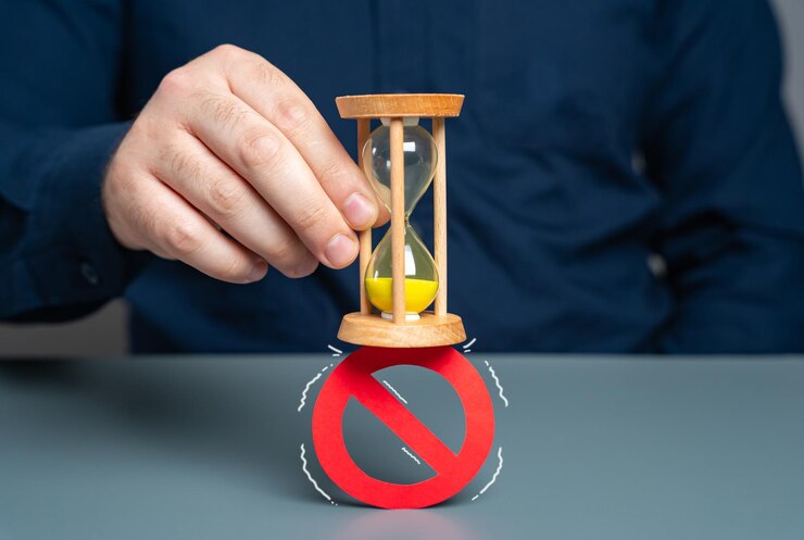 A man crushes a prohibition sign with an hourglass